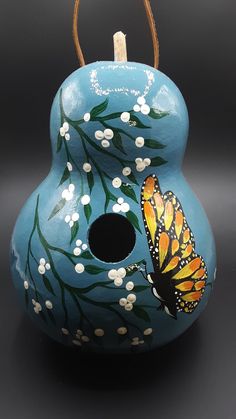 a blue vase with a butterfly painted on it