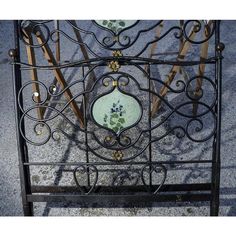 a wrought iron bed frame with flowers and leaves painted on the top, along with other metal furniture