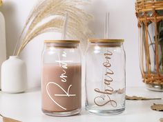 two personalized mason jars with straws on the top and one filled with liquid