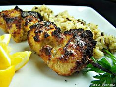 chicken with rice and lemon wedges on a white plate