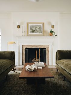 a living room with two couches and a coffee table in front of a fireplace