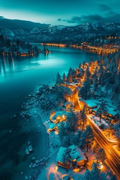 an aerial view of a lake at night with lights in the trees and snow on the ground