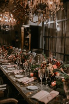 a long table is set with place settings and candles