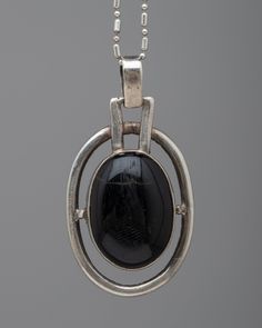 Silver Onyx Locket Modern Black Oval Link Jewelry, Black Sterling Silver Jewelry With Oval Link, Silver Pendant With Black Enamel, Timeless Metal Necklace With Polished Finish, Modern Metal Jewelry With Oval Pendant, Timeless Oval Black Enamel Jewelry, Modern Metal Oval Pendant Jewelry, Black Oval Link Jewelry For Gifts, Modern Onyx Necklaces With Polished Finish