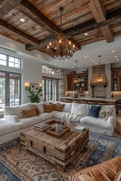 a living room filled with lots of furniture and a chandelier hanging from the ceiling