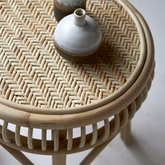 two vases sitting on top of a wicker table