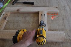 a man is holding a drill in his right hand while working on a piece of wood