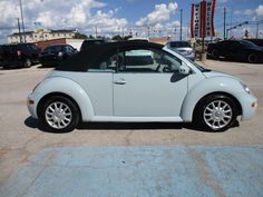 a small white car parked in a parking lot