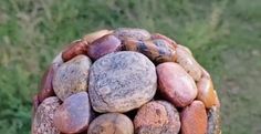 a bunch of rocks sitting on top of each other in front of a grass field