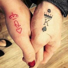 two people holding hands with matching tattoos on their fingers and wrist, both showing the word love