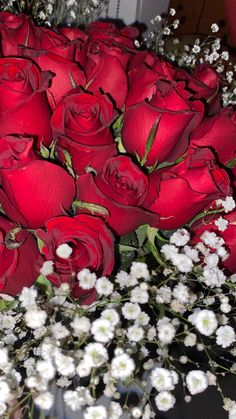 a bouquet of red roses and baby's breath