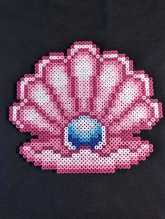 a pink and white beaded scallop on a black t - shirt with blue beads