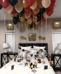 balloons are hanging from the ceiling above a bed