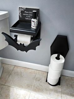 a bathroom with two toilet paper rolls and a bat shaped shelf