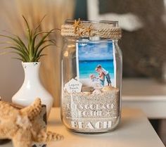 a glass jar filled with sand next to a starfish