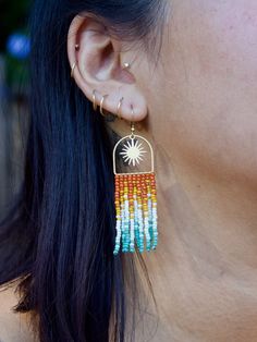 a close up of a person wearing some kind of earring with beads on it