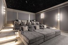 an empty movie room with couches and lamps on the walls, stars in the ceiling