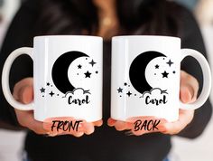 two white coffee mugs with the words camp and front back printed on them, held in both hands