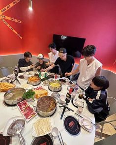 a group of people sitting around a table covered in food