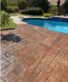 a brick patio next to a swimming pool