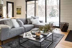 a living room filled with furniture and a large glass door leading to a snowy forest