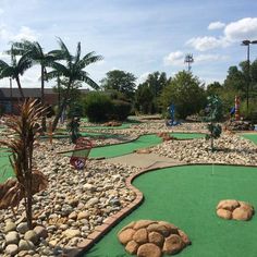 a miniature golf course with rocks and palm trees