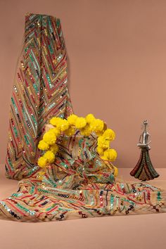 a vase with yellow flowers sitting on top of a table next to a decorative object