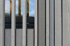 the side of a building with metal bars on it's sides and a clock tower in the background