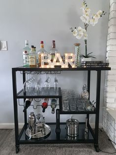 a bar cart filled with glasses and liquor bottles