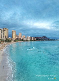 the beach in waiki'i is surrounded by high rise buildings and blue water