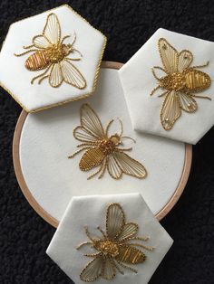 three embroidered bee coasters sitting on top of each other