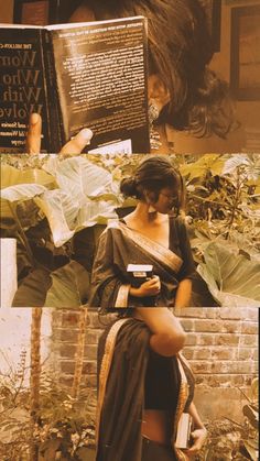 a woman standing next to a brick wall holding a book