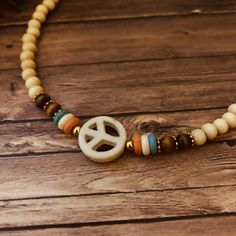 This is 13inches with an 2 inch extension has 4mm light beige wooden beads, some brown wooden beads also with beige ,turquoise and orange heishi beads and a 15mm with beige peace sign Howlite bead Adjustable Hippie Beaded Choker Necklace, Hippie Adjustable Beaded Choker Necklace, Hippie Style Adjustable Beaded Choker Necklace, Hippie Beaded Choker Necklace As Gift, Bohemian Adjustable Nickel-free Choker, Adjustable Nickel-free Bohemian Choker, Adjustable Bohemian Jewelry For Music Festivals, Trendy Hypoallergenic Jewelry For Festivals, Hippie Beaded Choker Necklace