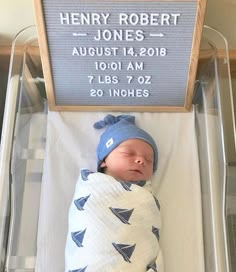 a baby in a crib with a name sign on the wall above it that reads henry robert jones