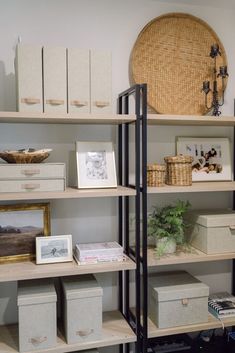 the shelves are full of boxes and pictures on them, with baskets in front of them