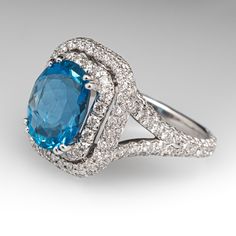 This enchanting ring is centered with one (1) richly hued oval cut Santa Maria aquamarine set into a four-prong setting. The double halo and shoulders of the ring are decorated with a total of two-hundred six (206) pavé/ prong set round brilliant cut diamonds. The ring measures 16.2mm at the top, rises 10.2mm above the finger, tapering to 2.0mm wide and 1.3mm thick at the base of the shank. The ring is currently a size 6.75 and sizing will be limitted due to the design. Please feel free to call with sizing inquires. Dazzling Oval Topaz Ring With Halo Setting, Formal Blue Topaz Diamond Ring With Halo Design, Elegant Oval Topaz Ring With Halo Design, Formal Oval Topaz Ring With Halo Design, Elegant Formal Halo Topaz Ring, Luxury Topaz Ring With Halo Design For Formal Occasions, Formal Oval Topaz Ring With Halo Setting, Luxury Topaz Ring With Halo Design, Gia Certified Oval Topaz Ring For Formal Occasions