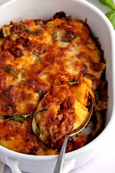 a casserole dish with meat, cheese and herbs in it on a table