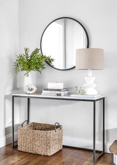 a white table with a mirror and basket on it