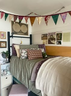 a bed room with a neatly made bed and lots of decorations on the wall above it