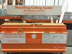 an orange and white box sitting on top of a floor next to a sign that says moulding cutting center