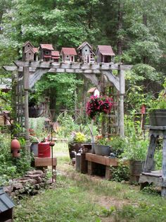 a garden with lots of potted plants and birdhouses