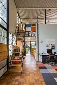 an open floor plan with stairs and desks