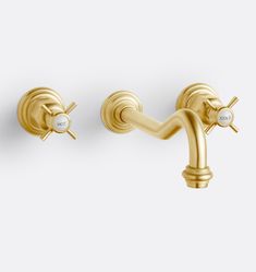 two gold faucets on a white wall, one is turned off and the other has