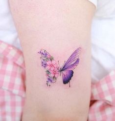 a woman's leg with a butterfly and flowers tattoo on her left side ribcage