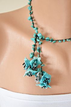 a woman's torso wearing a necklace with blue flowers on the front and sides