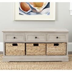 a white bench with baskets underneath it and a painting on the wall in the background