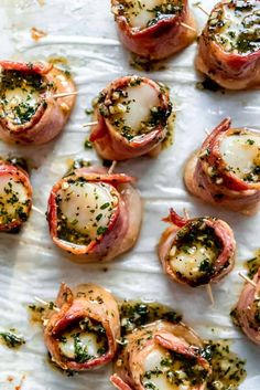 small appetizers with meat and cheese are on a sheet of waxed paper