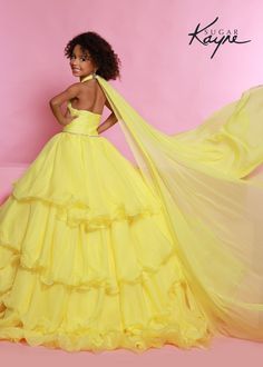 Sugar Kayne C305 Girls and Preteens Ruffle Pageant Ball Gown Cape Halter Formal DressOh s'cute!! This poly chiffon layered ballgown features a crisscross halter neckline with beaded trim along the waist. The train will float seamlessly across the stage, especially with the detachable cape. Oh s'cute!! This poly chiffon layered ballgown features a crisscross halter neckline with beaded trim along the waist. The train will float seamlessly across the stage, especially with the detachable cape.Colo Gown Cape, Detachable Cape, Johnathan Kayne, Sleeveless Chiffon Dress, Mnm Couture, Jasz Couture, Plastic Dress, Cinderella Divine, Dress Ball Gown