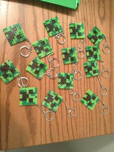 several pieces of green and black beaded items on a wooden surface with scissors in the middle