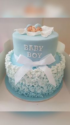 a blue and white cake with a baby boy on top